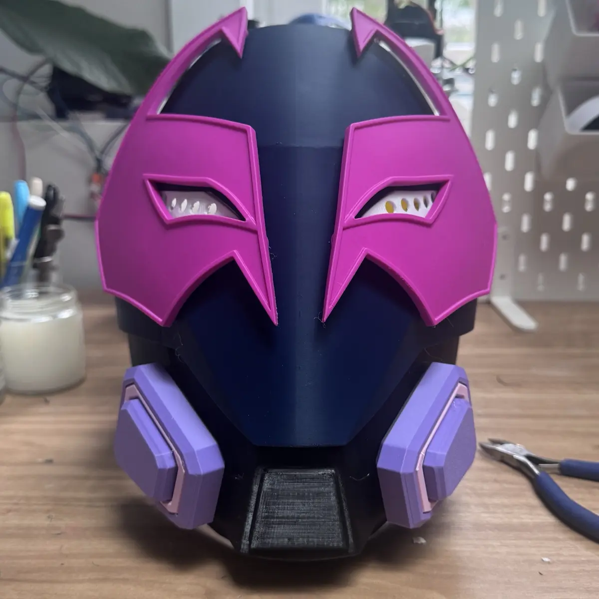 3D-printed helmet-style mask in navy with a magenta faceplate and lavender cheek vents